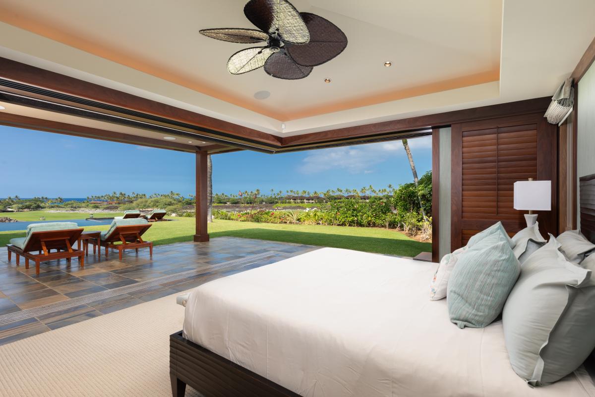 Primary suite with a Cal king bed and lanai access overlooking the Pacific.