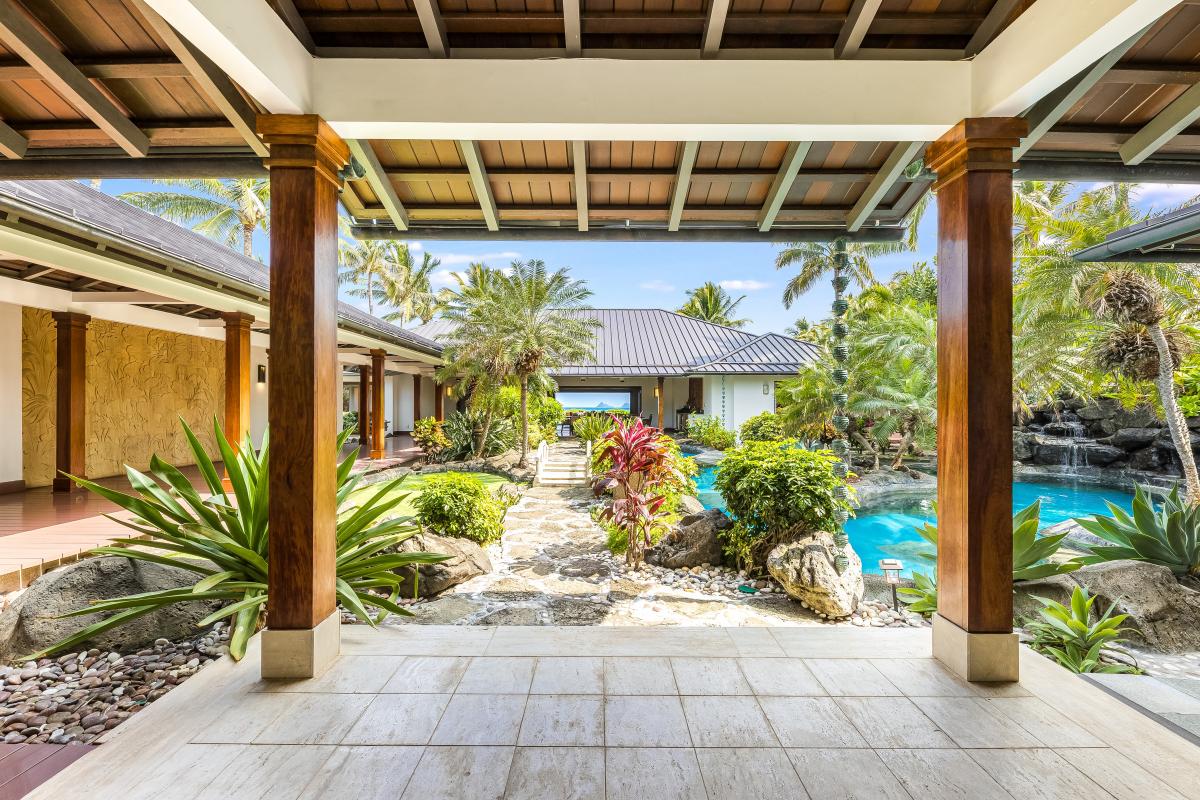 Zen-style covered walkway overlooking koi pond and tropical gardens.
