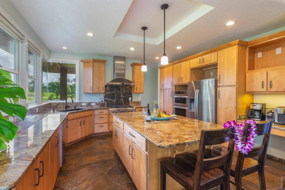 Pohaku Villa’s fully equipped kitchen with stainless steel appliances and warm wood cabinetry is ideal for group cooking.
