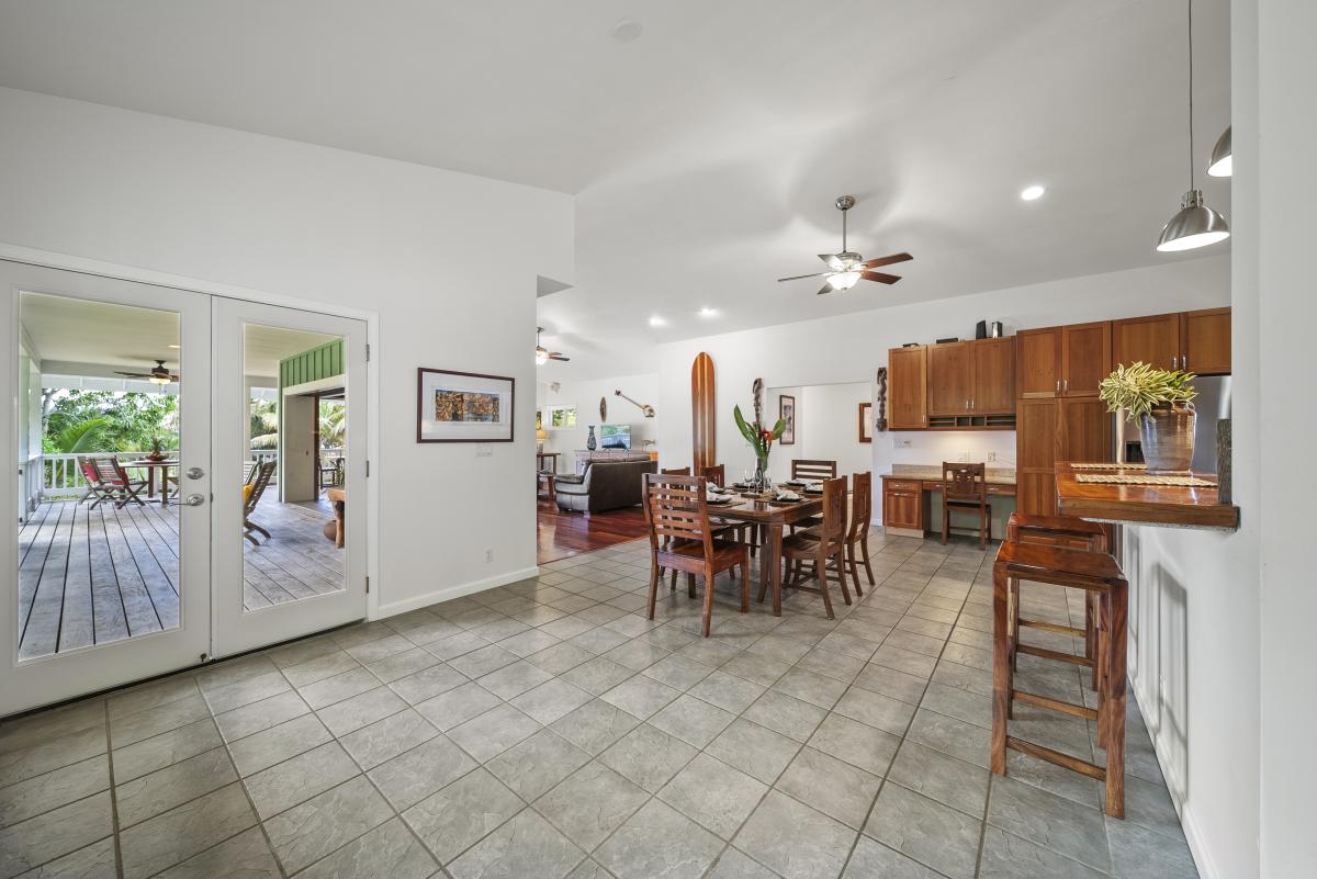 Bright great room with open floor plan — wood floors, high ceilings, and direct lanai access.