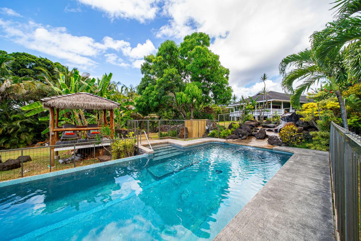Sparkling private lap pool surrounded by lush tropical foliage — your own garden oasis.
