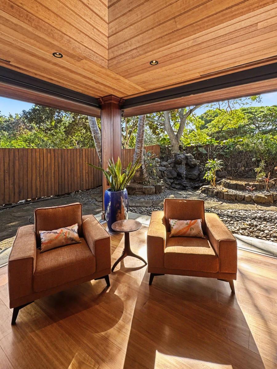Unwind in your private covered terrace where warm wood ceiling meets garden views, perfect for morning coffee or evening relaxation.