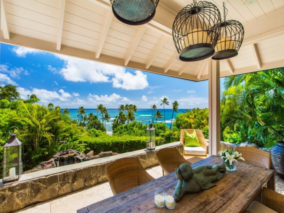 Covered lanai dining space overlooking the coastline and Diamond Head setting.