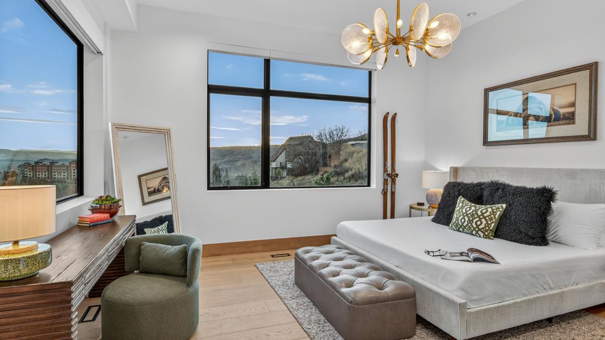 Wake up to stunning mountain views through floor-to-ceiling windows in your stylish bedroom retreat with premium furnishings.