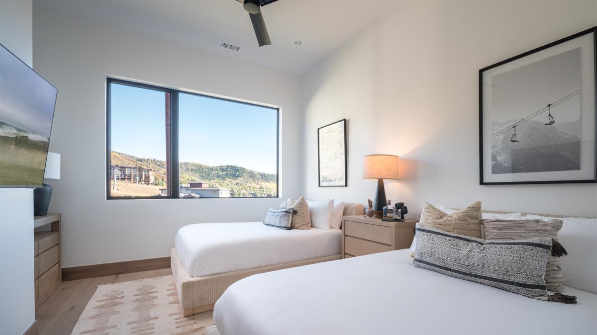 Rest peacefully in your twin bedroom with sweeping mountain views and modern alpine comfort.