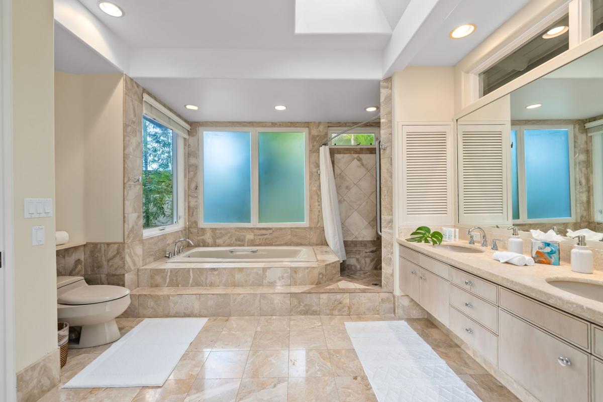 Unwind in your marble sanctuary with a soaking tub, separate shower, and garden views through frosted glass.