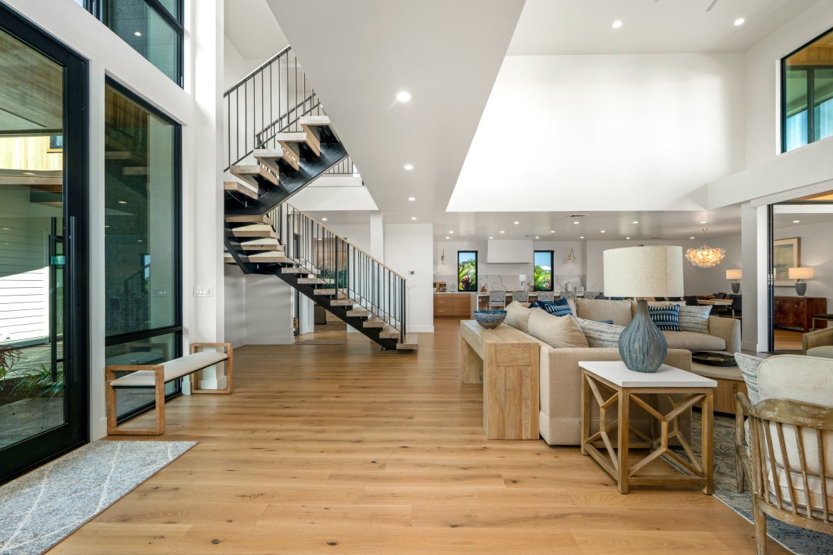 The spacious open-plan living area has soaring ceilings, warm wood floors, and designer furnishings that create the perfect atmosphere for memorable moments.