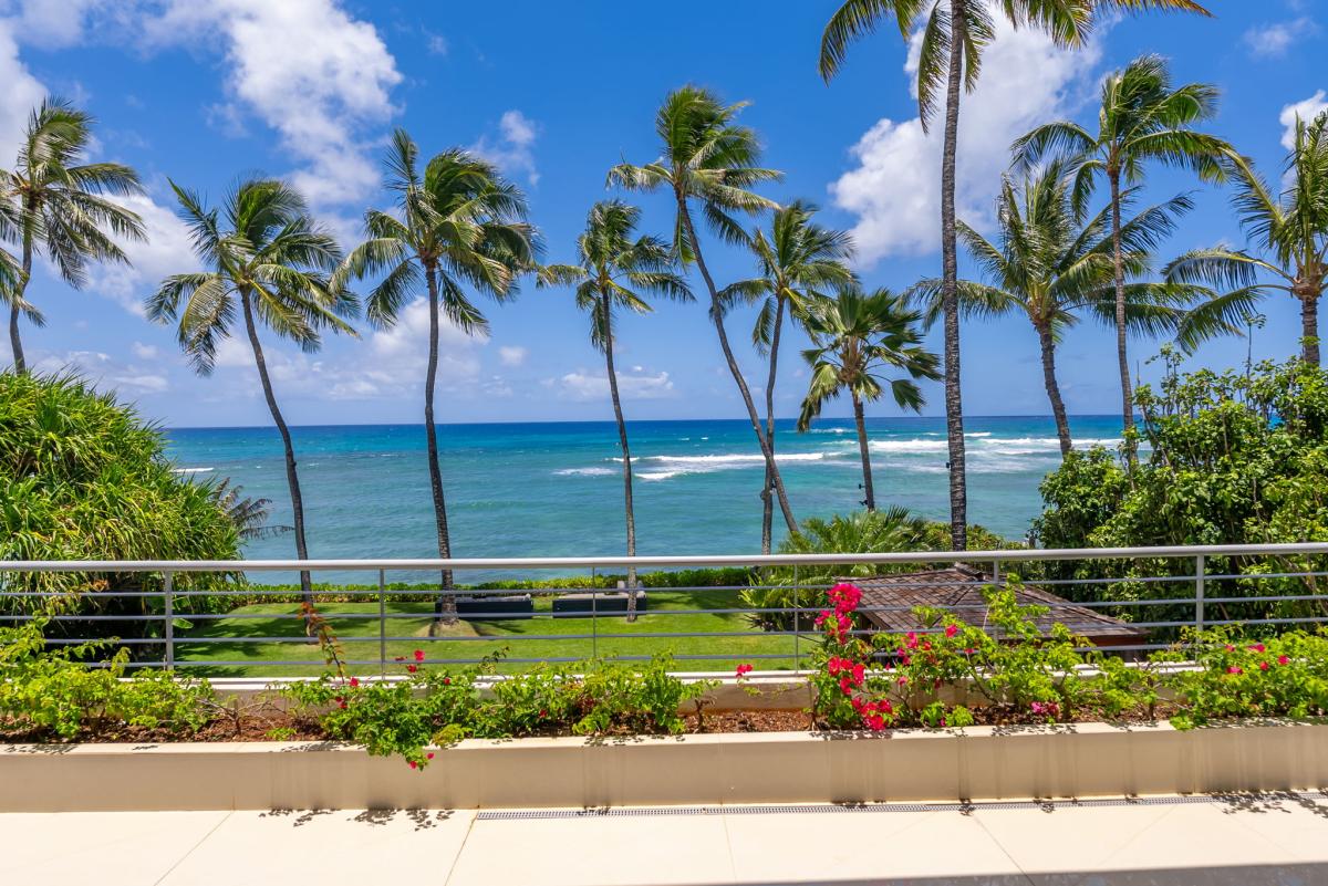 The property offers oceanfront views with swaying palms and lush gardens framing turquoise waters and pristine sandy shores just steps away.