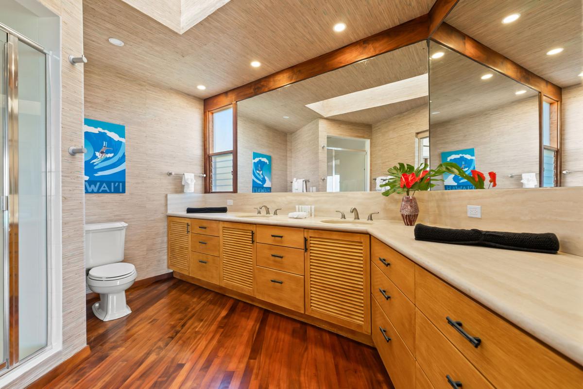 Refresh in your spa-like bathroom with warm wood accents, dual vanities, and tropical touches that bring Hawaii's island spirit indoors.