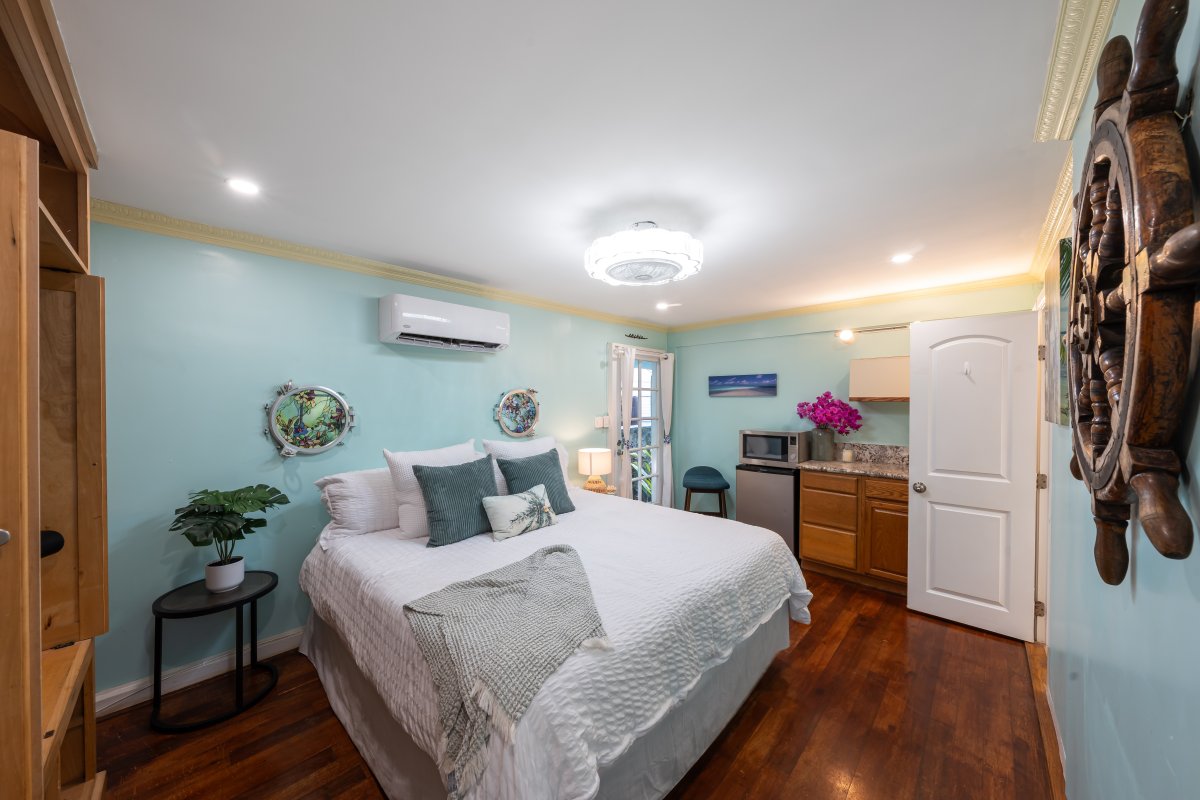 A ship's wheel over the bed sets the nautical tone in this spacious bedroom.