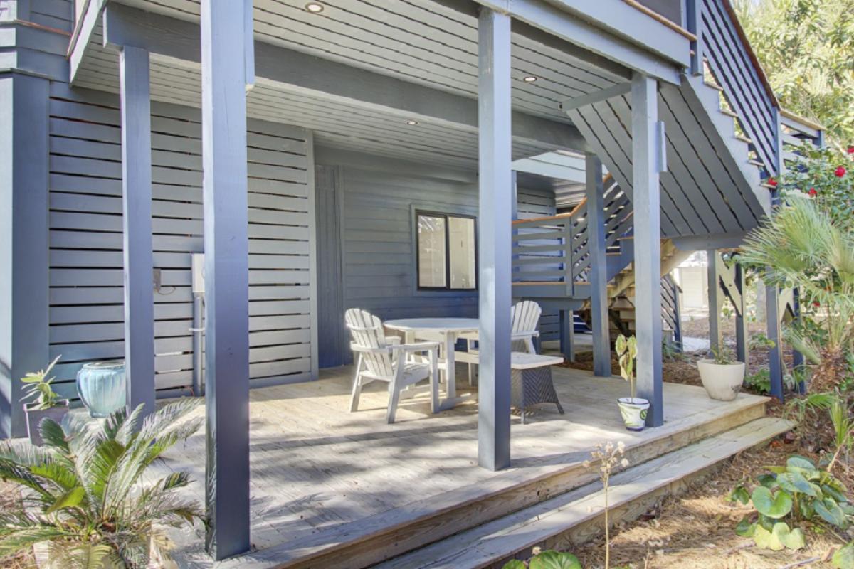 - Enjoy your morning coffee or evening chats on this shaded deck with Adirondack chairs - Sheltered patio space provides the perfect escape from sun or rain - Charming setup beneath the stairs with calming natural tones and privacy panels