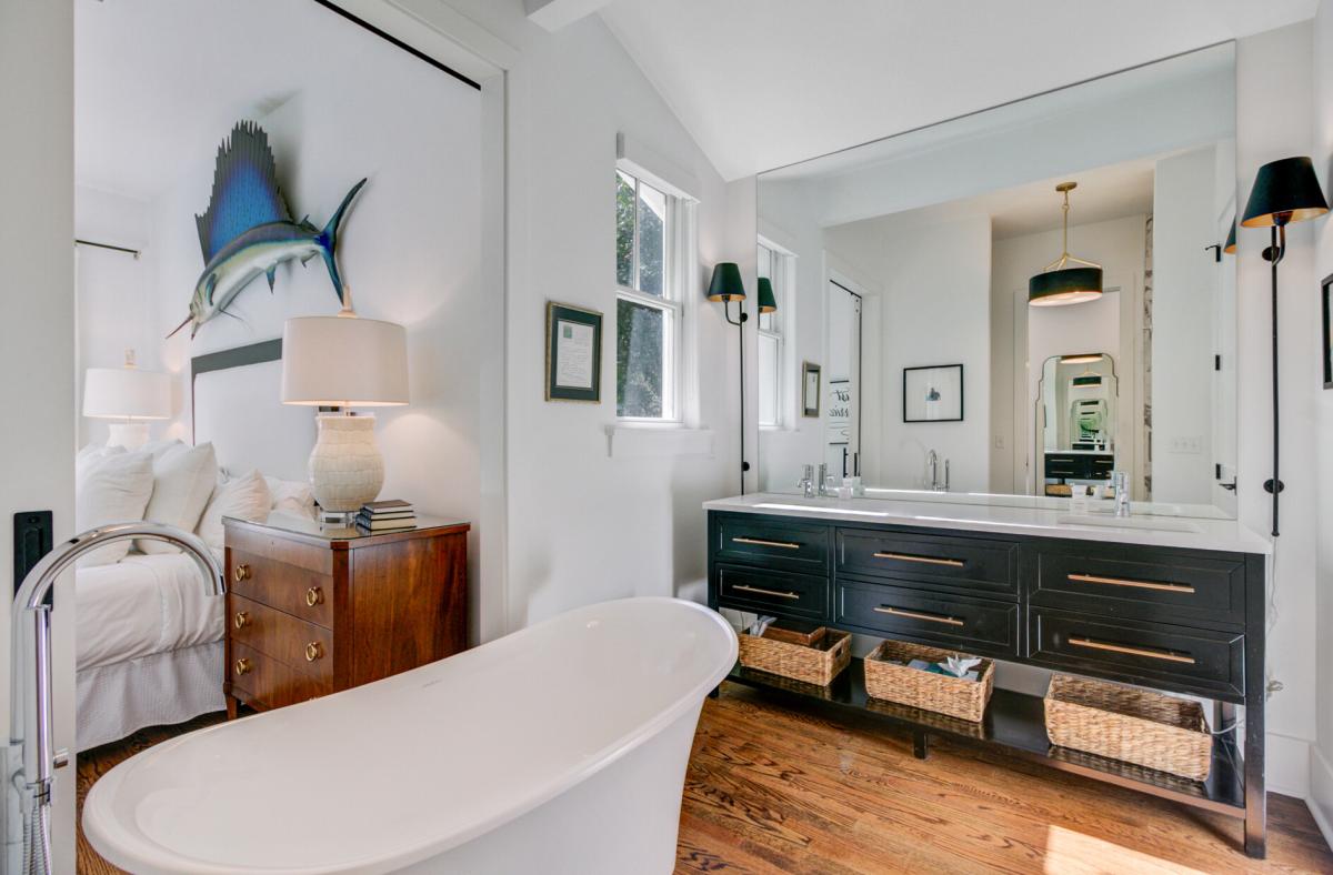 Soak in your luxurious freestanding tub while admiring coastal-inspired artwork in this elegantly designed master bathroom retreat.