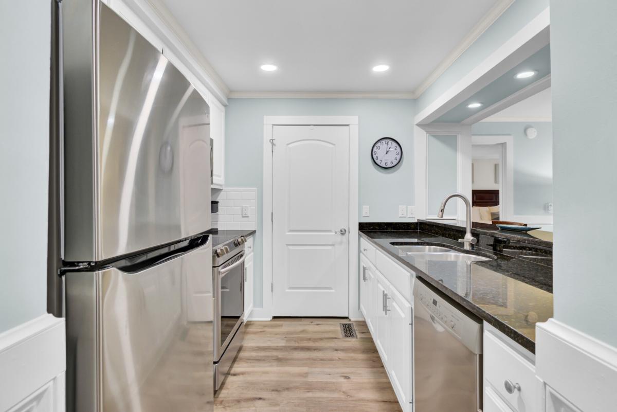 Step into your bright, modern galley kitchen with sleek granite counters and stainless steel appliances ready for your culinary adventures.