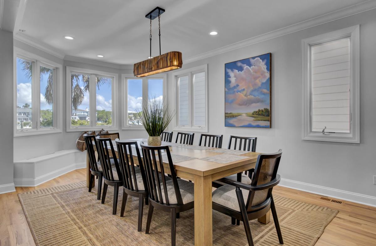Gather your group around this elegant dining table where natural light streams through panoramic windows, creating the perfect setting for memorable meals together.