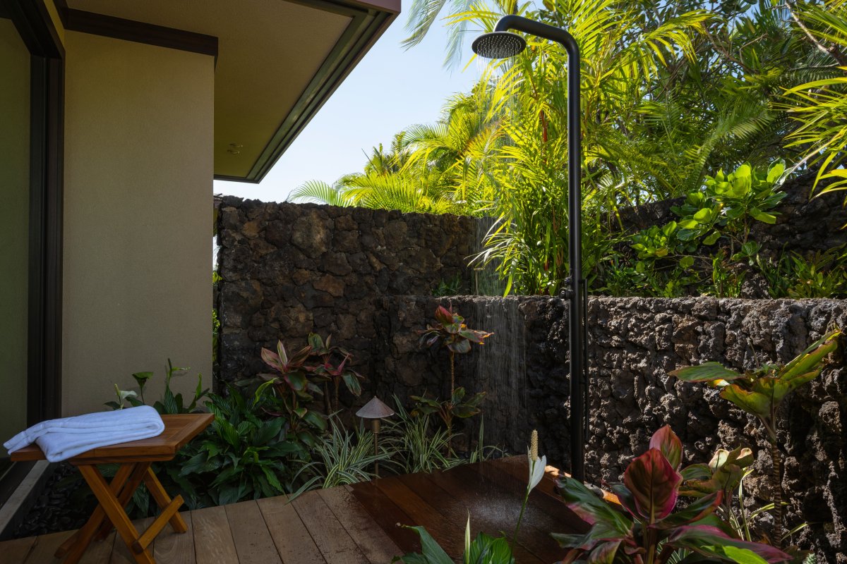 Primary Suite #1: Step into your private outdoor shower oasis, where tropical palms and lush gardens create the perfect natural spa experience.