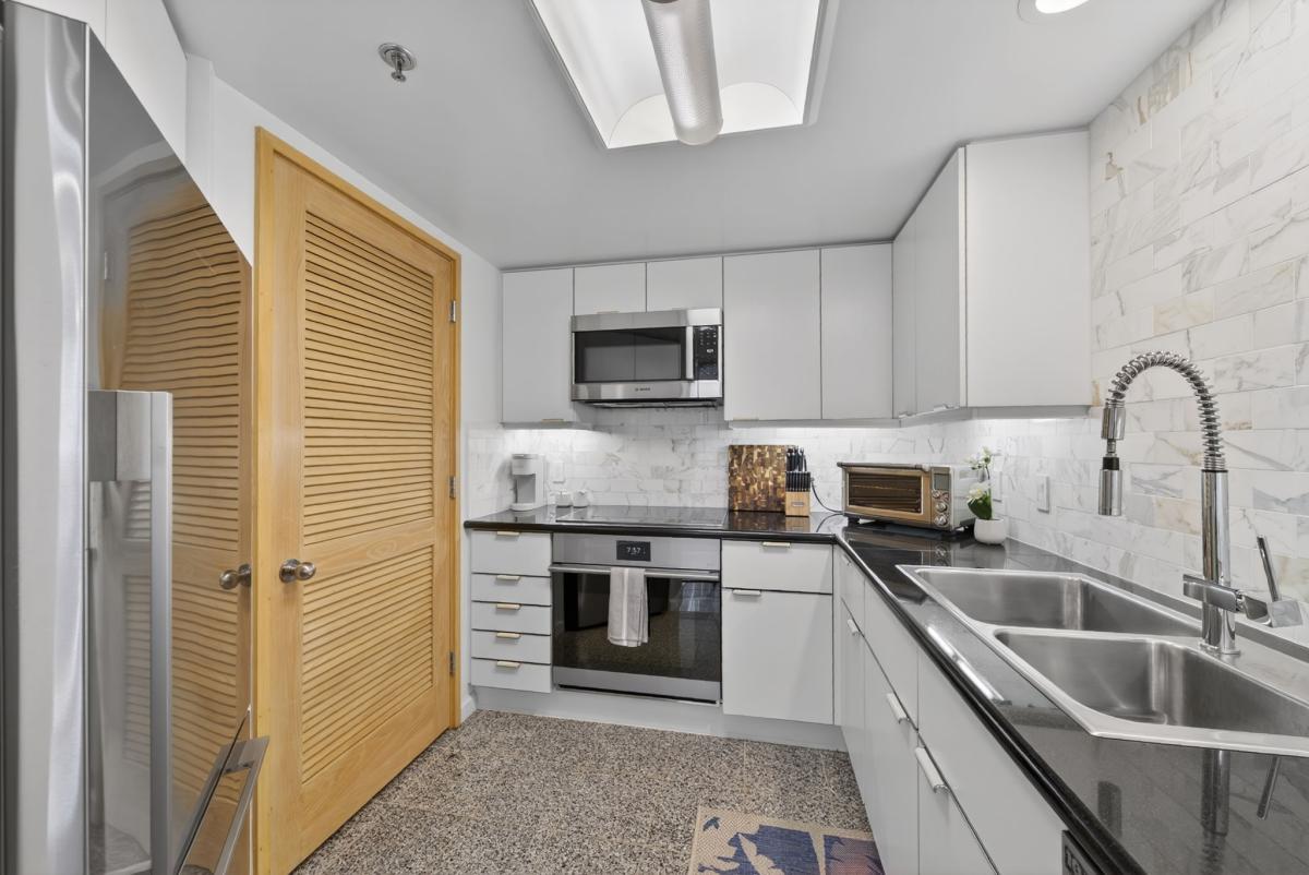 Prepare island meals in the refreshed kitchen with sleek appliances and stone counters.