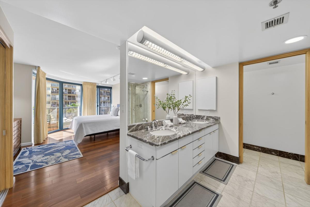 Enjoy extra space with dual vanities, rich marble finishes, and bedroom access nearby.