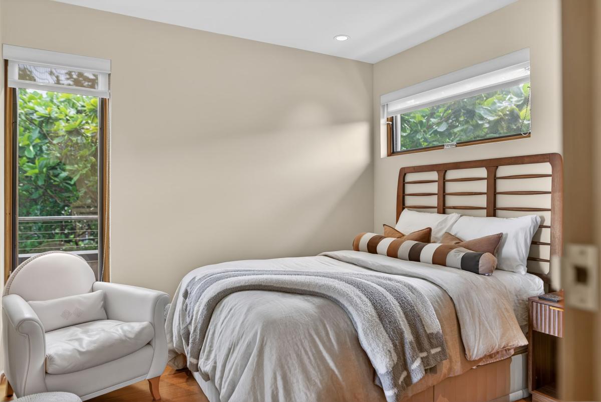 Natural light fills this cozy guest bedroom, creating a calm and comfortable place to unwind after a day on the North Shore.