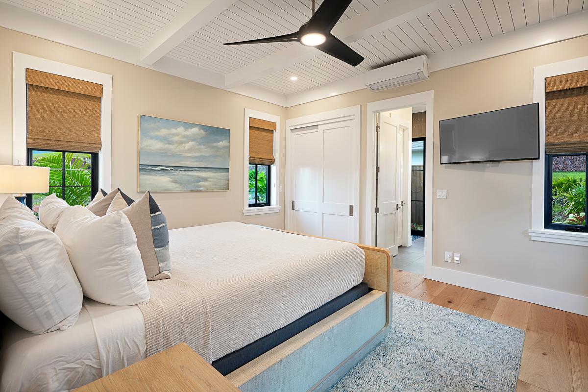 Crisp linens and a ceiling fan turning slow above the third bedroom's king.