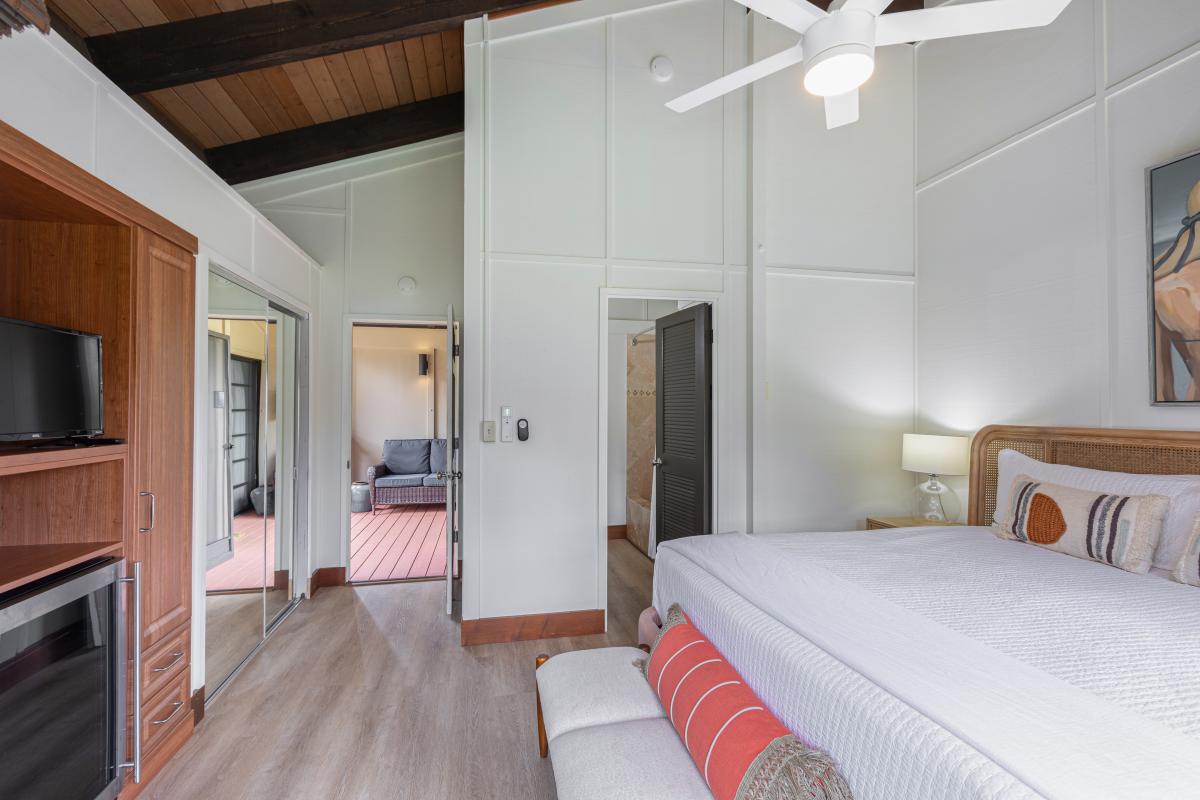 The lockout bedroom features a plush king bed, calming tropical tones, and full A/C comfort—making it a peaceful retreat within the home.
