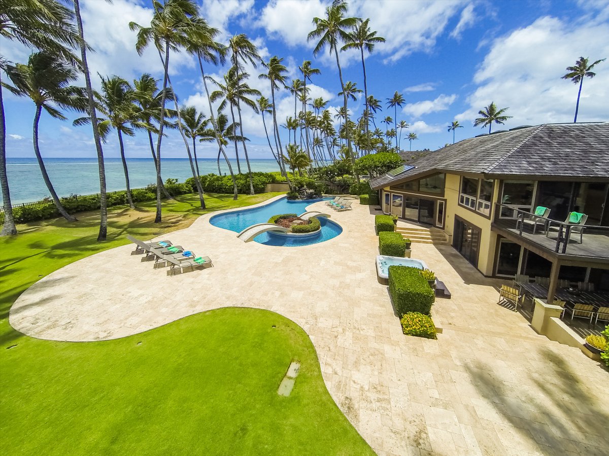 From above, the lawn runs from the lanai roofline all the way to the shoreline.