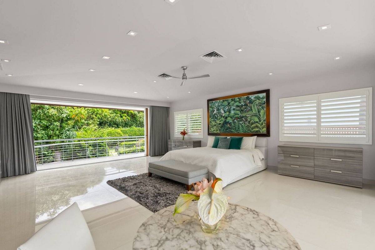 A single orchid on the bed, garden doors just past it, and little else to do.