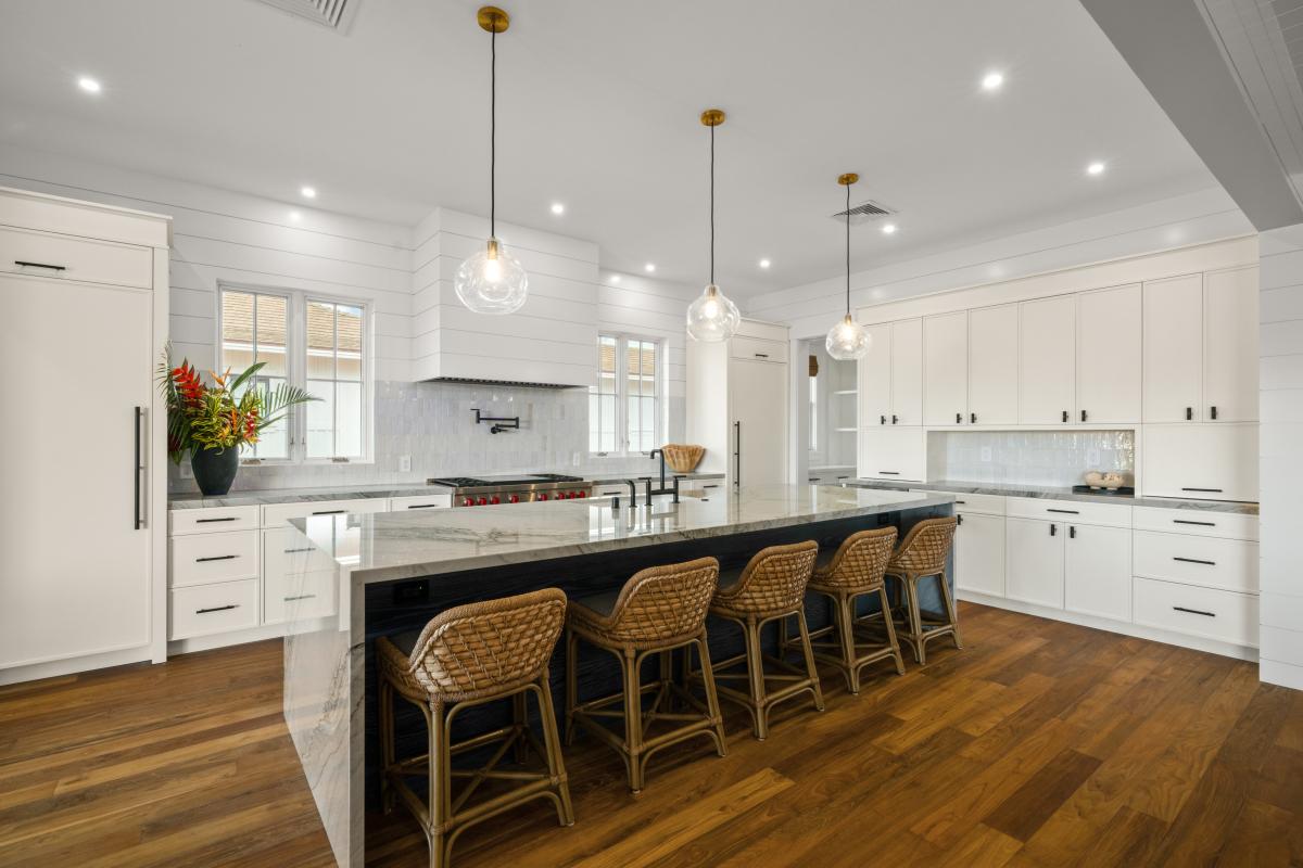 White cabinets, woven stools, and counter space that never runs out.