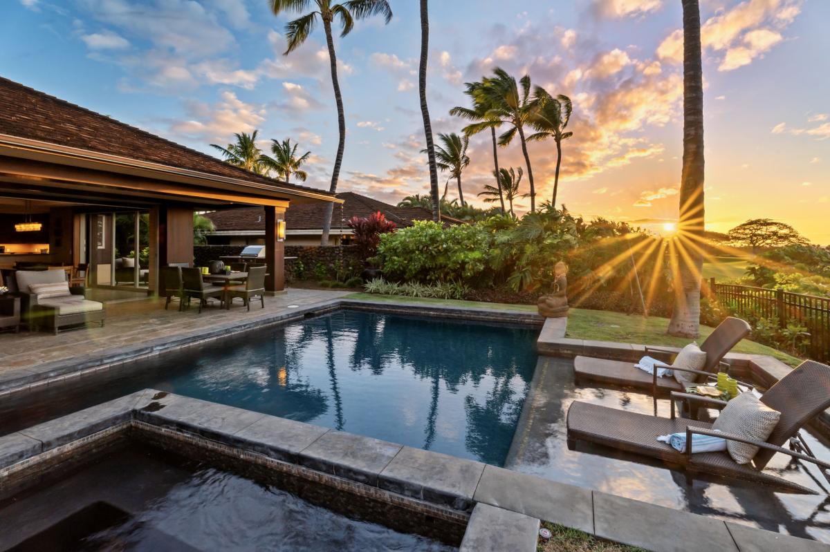 Aim the loungers at the sunset, the sky going orange behind the palms.